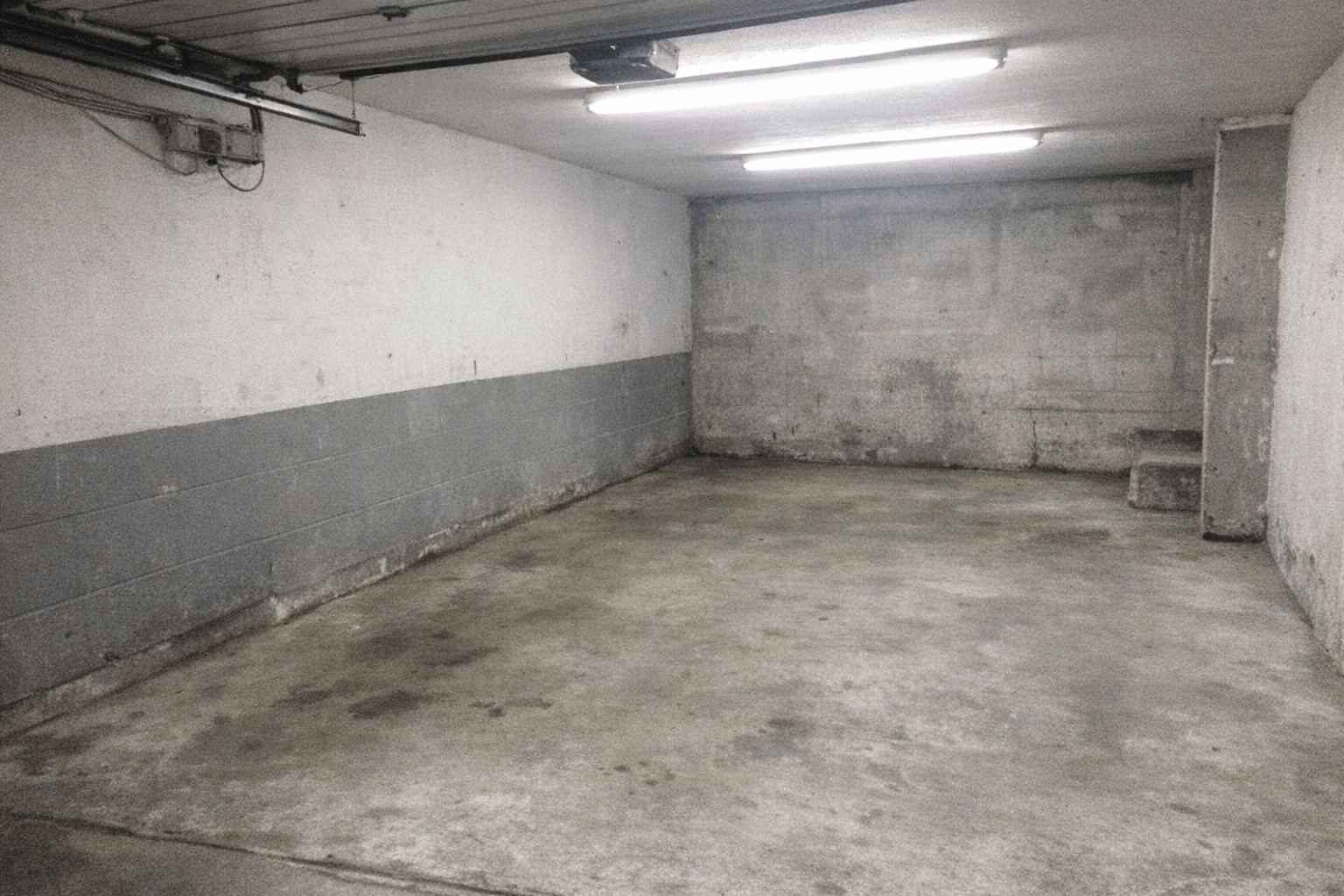 Aufgeräumte Garage mit freier Einfahrt und sortierten Reststoffen am Transporter