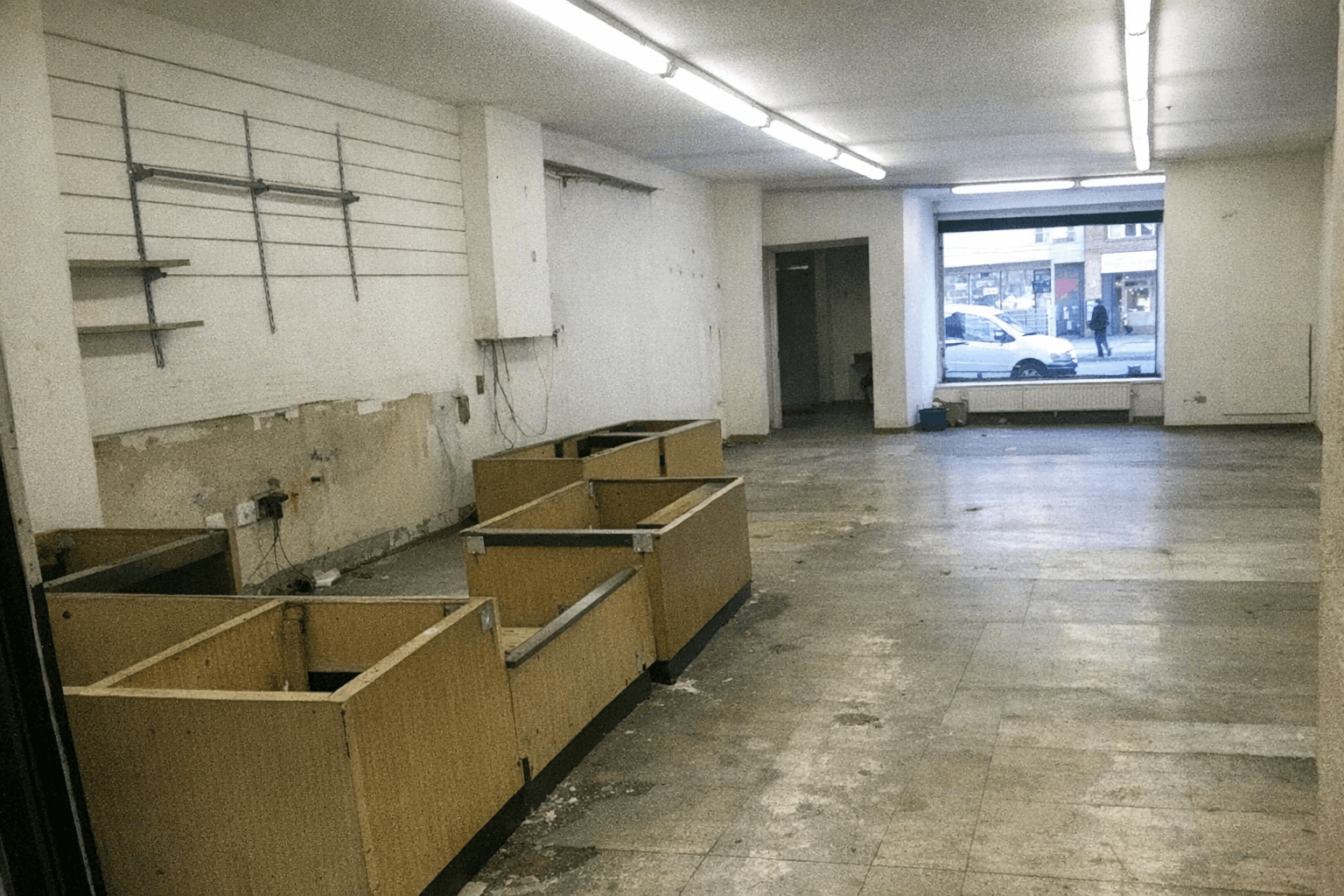 Leerer Verkaufsraum mit abgebautem Tresen und freier Schaufensterfront