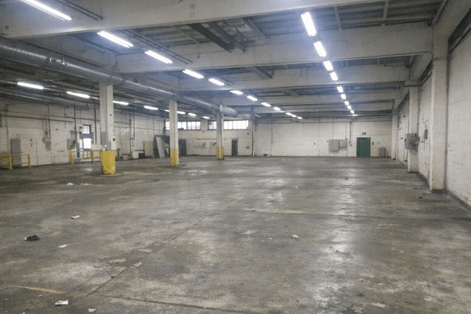 Große Halle nach Räumung mit demontierten Regalreihen und sauberem Boden